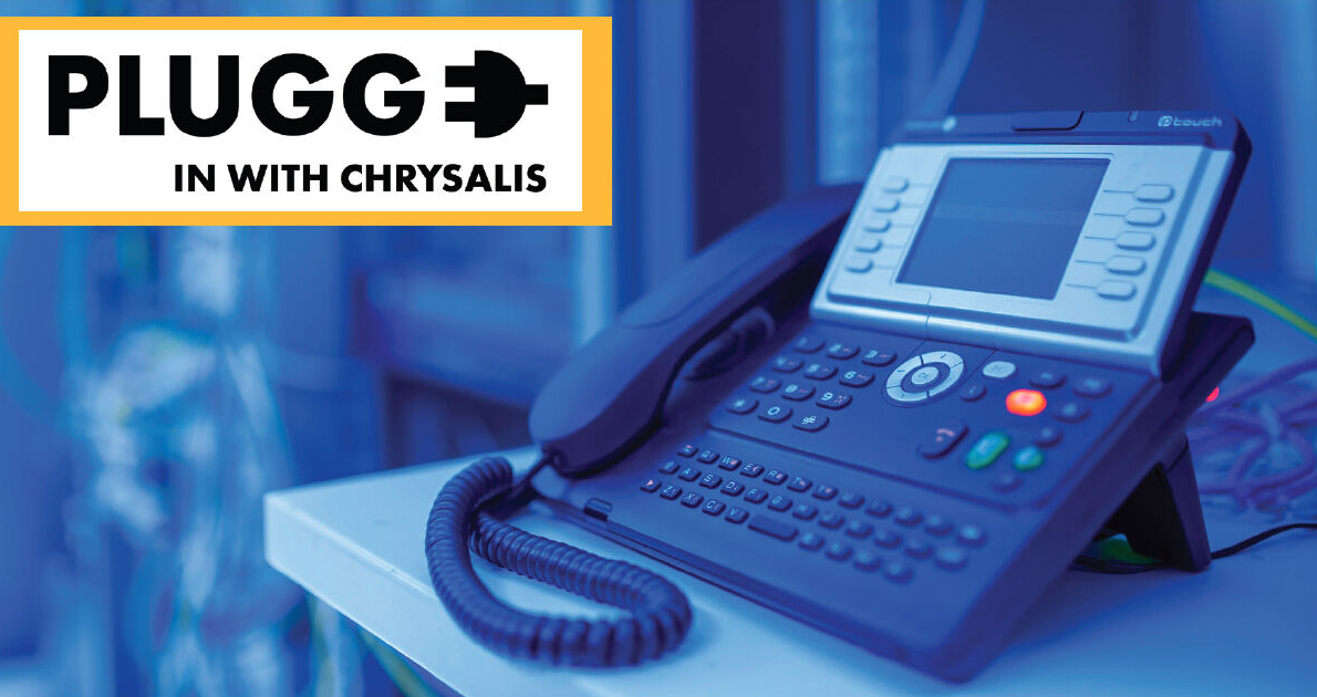 Office desk phone with the Plugged In with Chrysalis logo